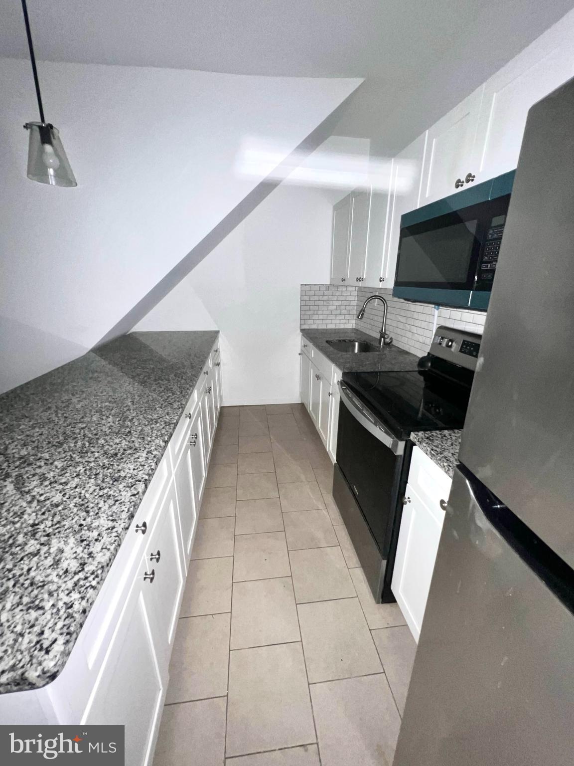 7034 North Broad Street Philadelphia, PA 19126 - Photo 2 of 13 a kitchen with stainless steel appliances kitchen island granite countertop a sink stove and cabinets