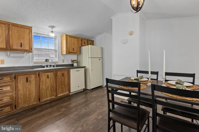 a kitchen with a table chairs sink and cabinets