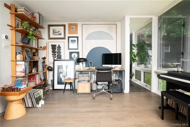 a view of a workspace with furniture and a bookshelf