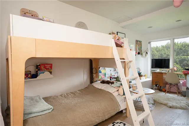 a bedroom with a large bed and a painting on the wall