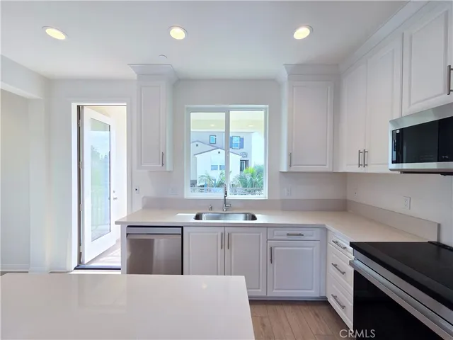 a kitchen with stainless steel appliances granite countertop a sink and a stove