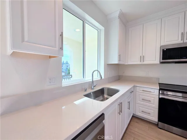a kitchen with a sink cabinets and window