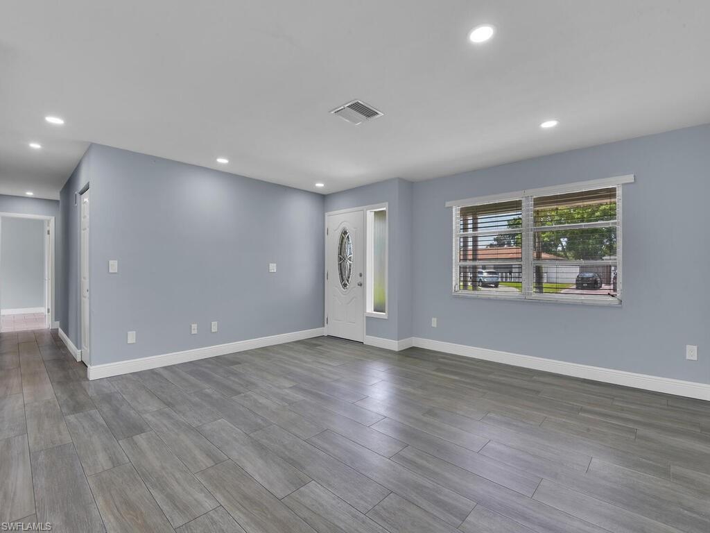 1958 41st Terrace Southwest Naples, FL 34116 - Photo 12 of 28 an empty room with wooden floor and windows