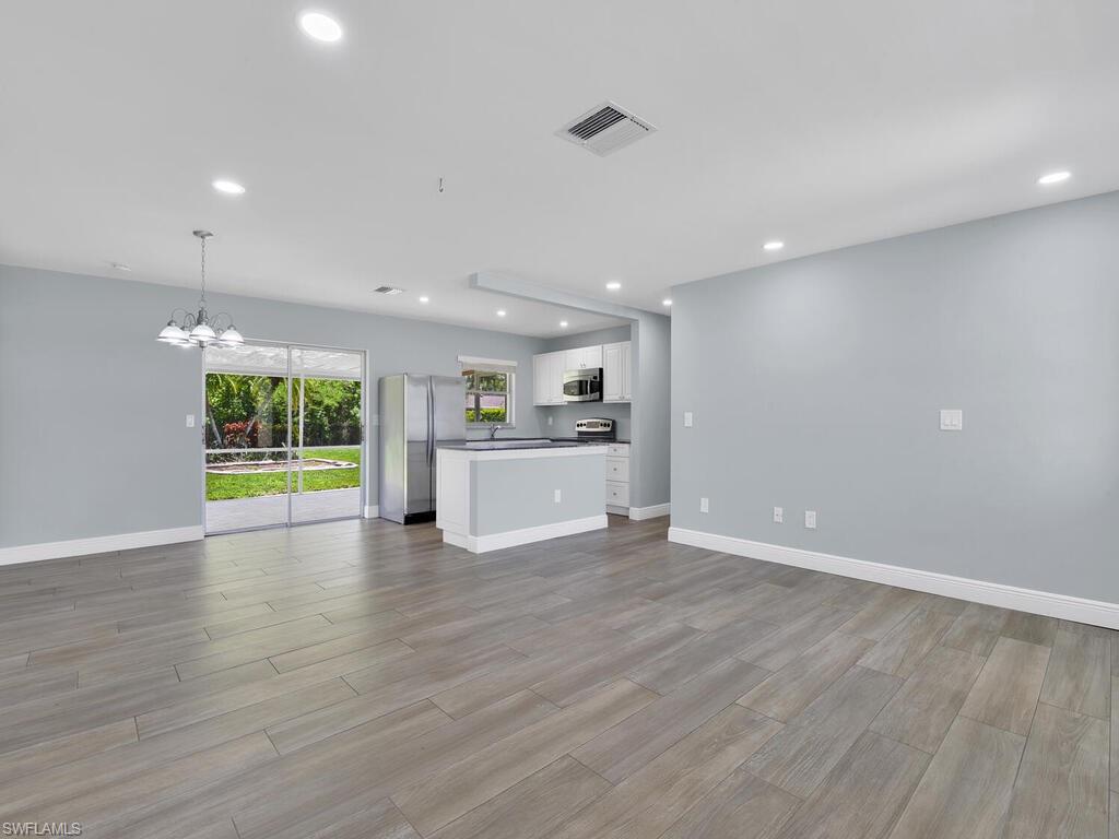 1958 41st Terrace Southwest Naples, FL 34116 - Photo 14 of 28 a view of an empty room with wooden floor and a window