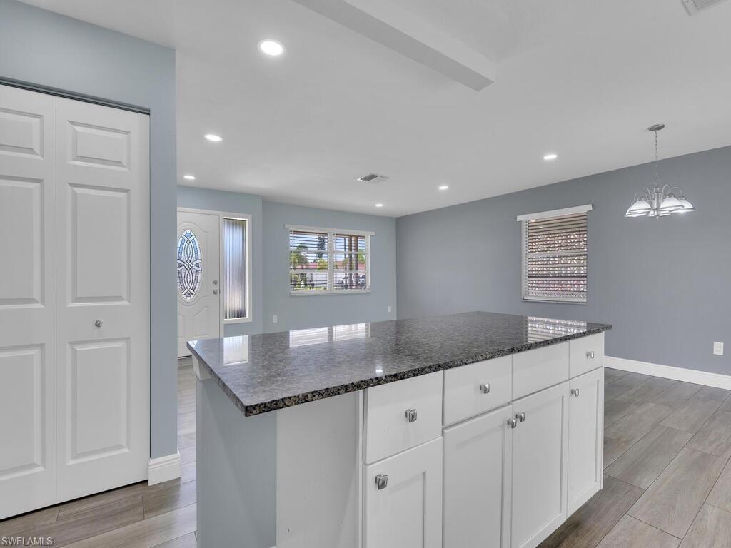 1958 41st Terrace Southwest Naples, FL 34116 - Photo 16 of 28 a kitchen with granite countertop white cabinets and sink