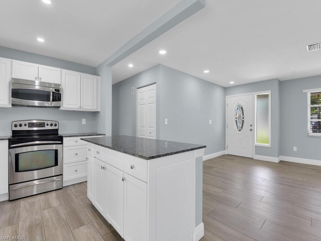 1958 41st Terrace Southwest Naples, FL 34116 - Photo 17 of 28 a kitchen with granite countertop a stove and a sink