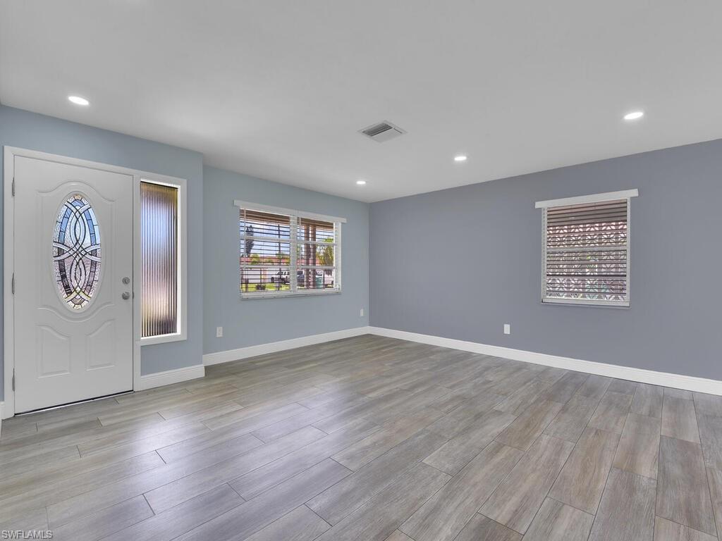 1958 41st Terrace Southwest Naples, FL 34116 - Photo 2 of 28 an empty room with wooden floor and windows