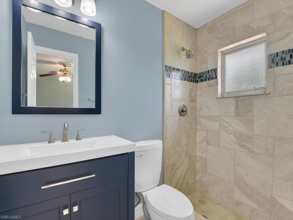 1958 41st Terrace Southwest Naples, FL 34116 - Photo 5 of 28 a bathroom with a toilet a sink and mirror