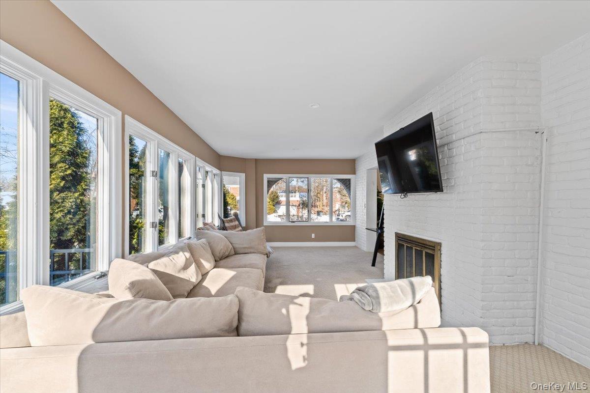 25 Pond Park Road Great Neck, NY 11023 - Photo 11 of 45 a living room with furniture a flat screen tv and a fireplace