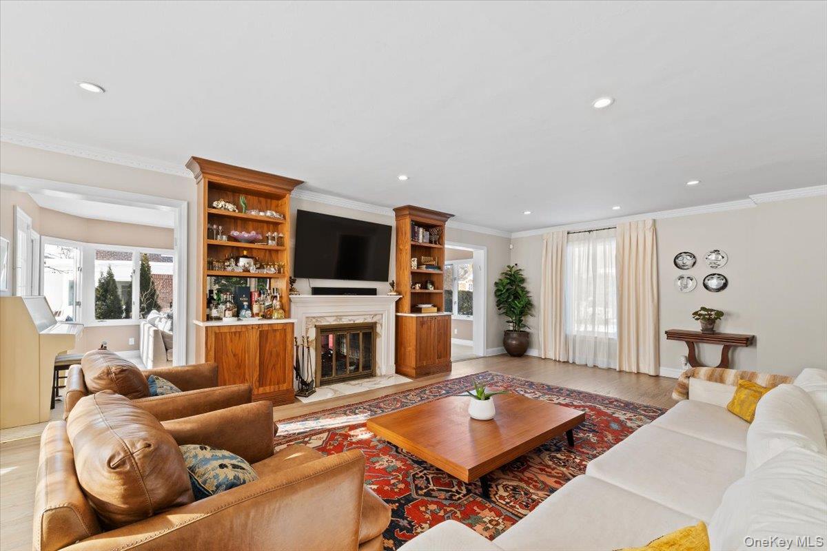 25 Pond Park Road Great Neck, NY 11023 - Photo 7 of 45 a living room with furniture a flat screen tv and a fireplace