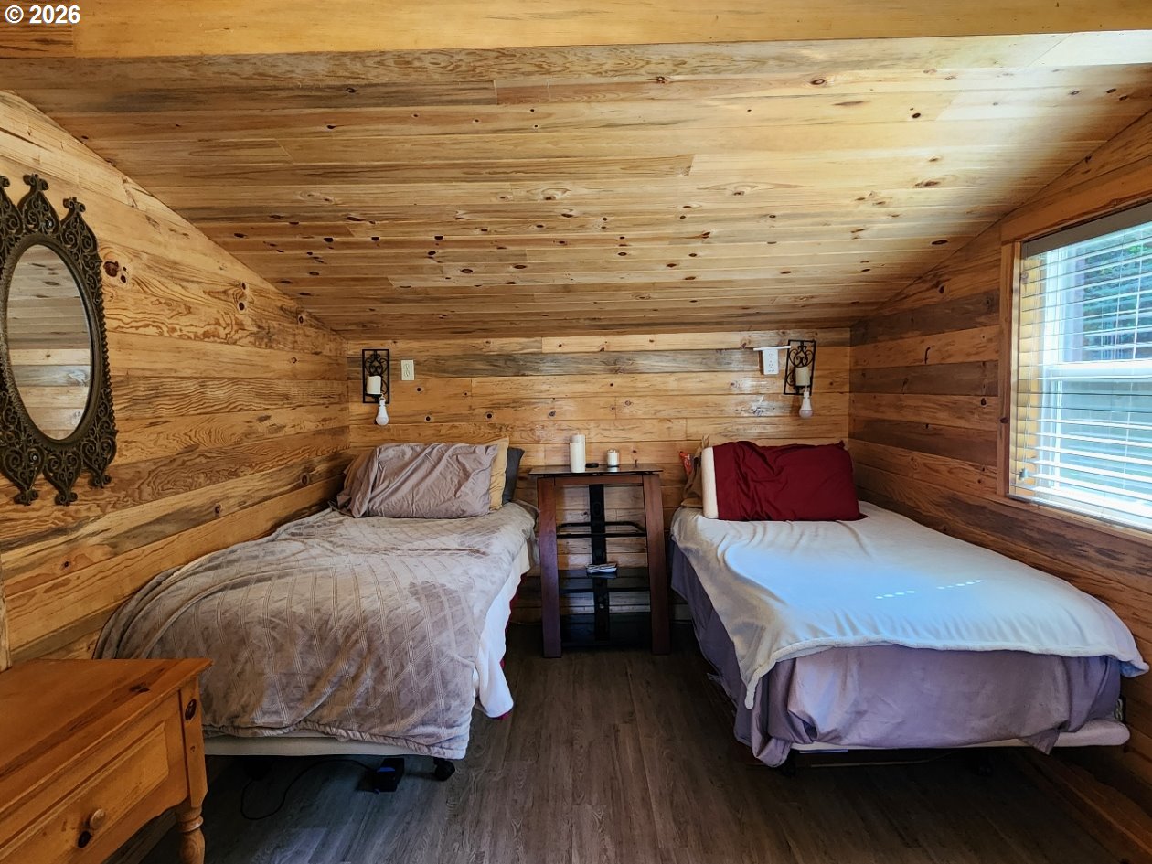 93490 Fir Road Port Orford, OR 97465 - Photo 27 of 47 a bedroom with a bed and wooden floor