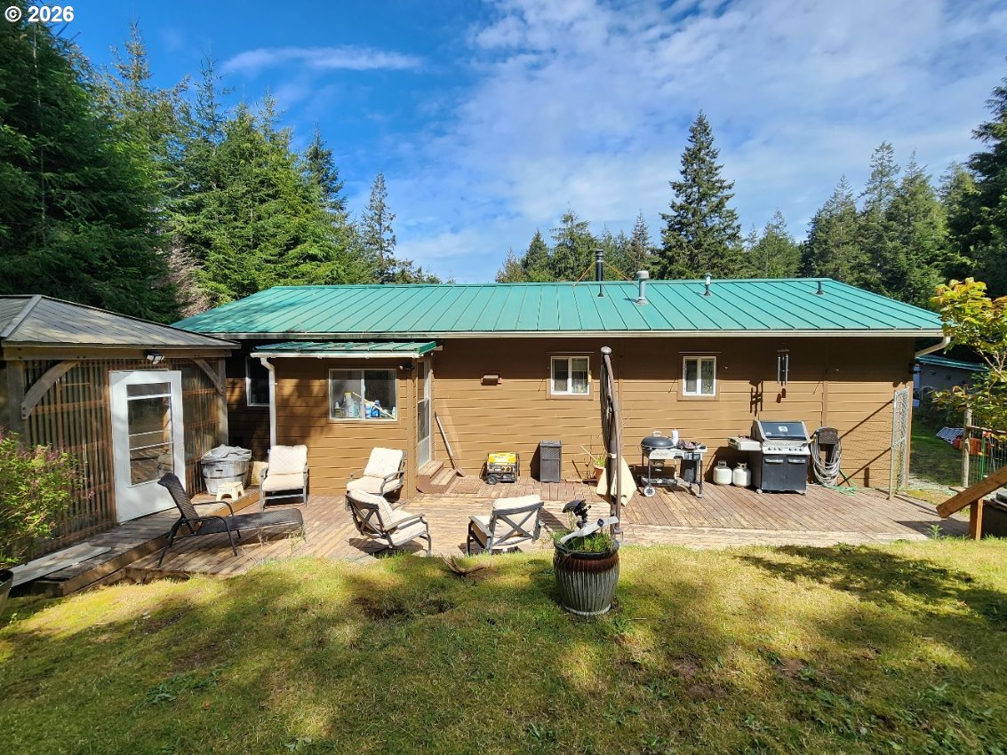 93490 Fir Road Port Orford, OR 97465 - Photo 6 of 47 a view of a patio with table and chairs under an umbrella
