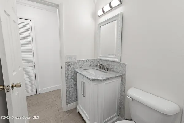 a bathroom with a granite countertop sink toilet and mirror