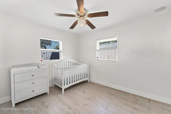 a bedroom with a baby bed window and a window