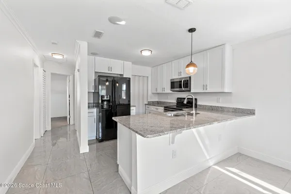 a kitchen with sink refrigerator and microwave