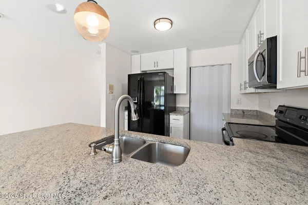a kitchen with stainless steel appliances a sink and a refrigerator