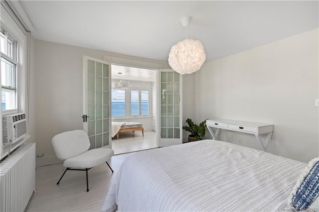 19 Soundview Drive Westport, CT 06880 - Photo 23 of 40 a bedroom with a bed and a chandelier