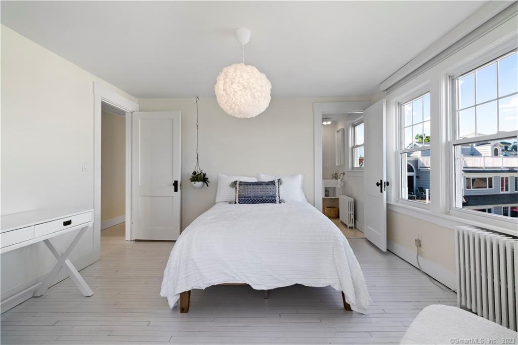 19 Soundview Drive Westport, CT 06880 - Photo 24 of 40 a bedroom with a bed and a chandelier