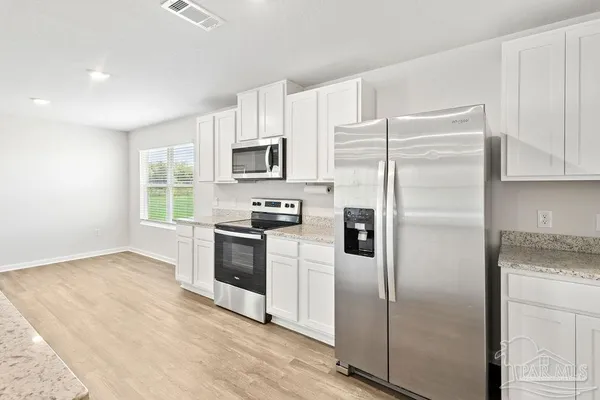 a kitchen with a refrigerator stove and microwave