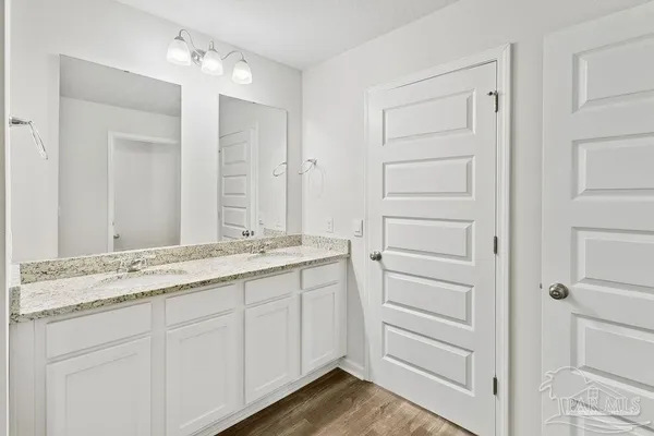 a bathroom with a granite countertop sink and a mirror