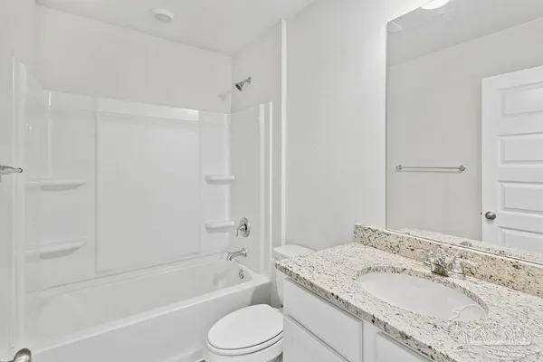 a bathroom with a granite countertop sink mirror toilet and bathtub