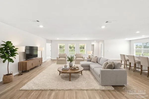a living room with furniture flat screen tv and a large window