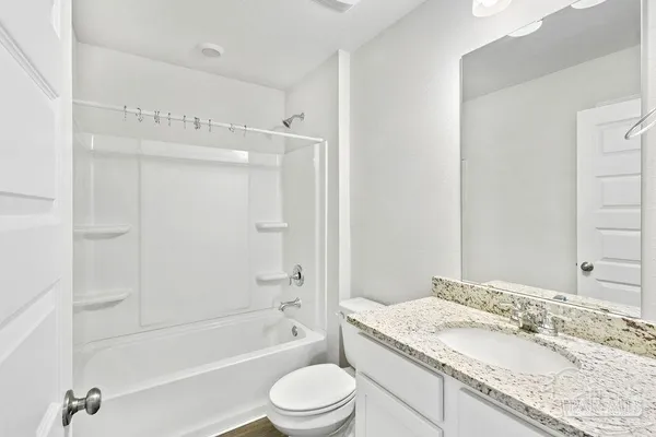 a bathroom with a granite countertop sink a toilet and shower