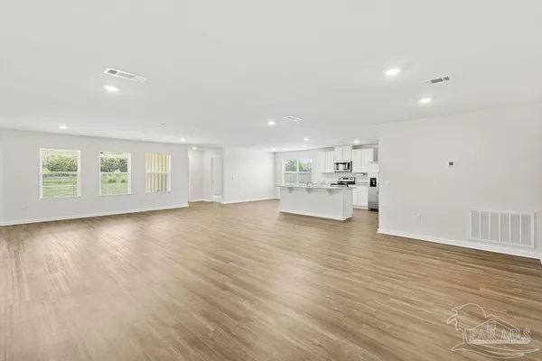 a view of empty room with wooden floor
