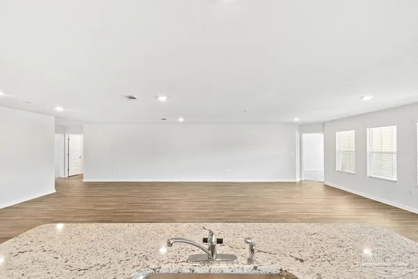 an empty room with wooden floor and a window
