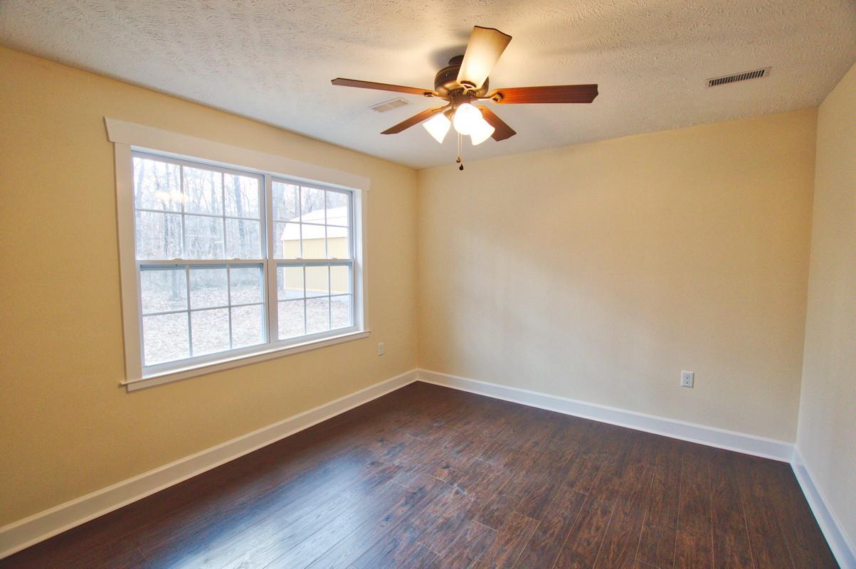 316 Talbert Road Morrison, TN 37357 - Photo 13 of 19 an empty room with wooden floor fan and windows