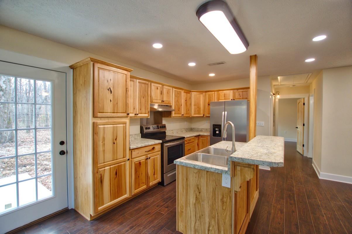 316 Talbert Road Morrison, TN 37357 - Photo 6 of 19 a kitchen with stainless steel appliances granite countertop a refrigerator a sink dishwasher a stove and white countertops with wooden floor