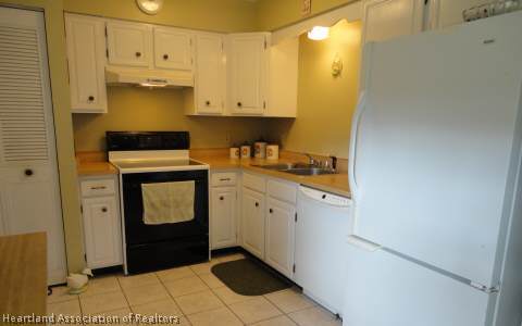 203 Longview Road Sebring, FL 33870 - Photo 4 of 12 a kitchen with a sink and a refrigerator