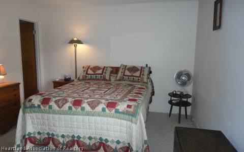 203 Longview Road Sebring, FL 33870 - Photo 8 of 12 a bedroom with a bed and a lamp on dresser