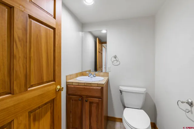 a bathroom with a toilet sink vanity and mirror