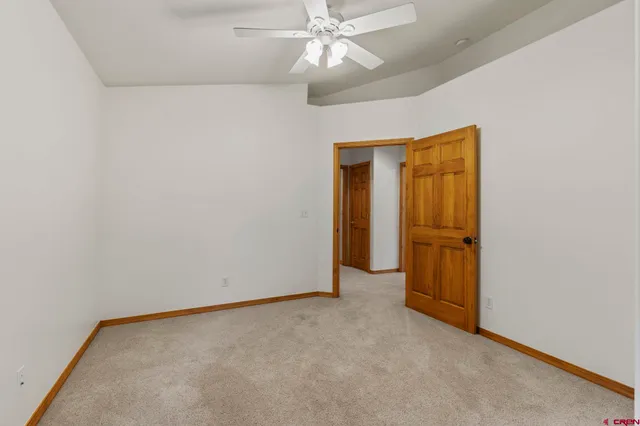an empty room with a ceiling fan and closet area