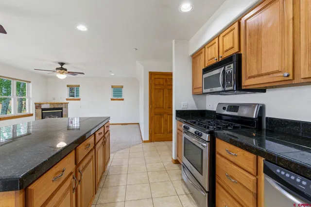 a kitchen with stainless steel appliances granite countertop a stove a sink and a microwave