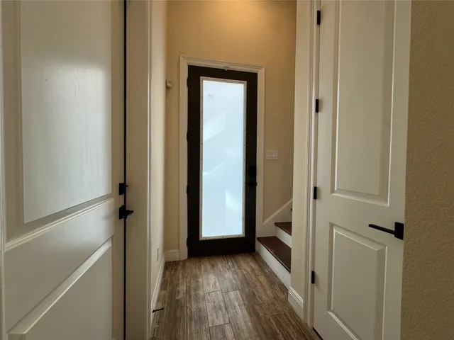 a view of a hallway with wooden floor and staircase