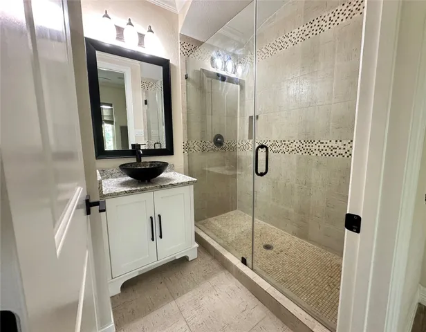 a bathroom with a granite countertop sink a mirror and a shower