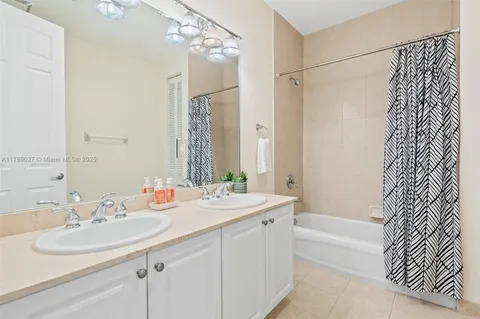 a bathroom with a sink double vanity mirror and a bathtub
