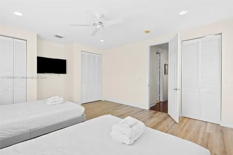 a bedroom with a large bed and a flat tv screen