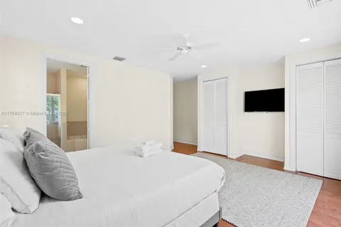 a bedroom with a large bed and a flat screen tv