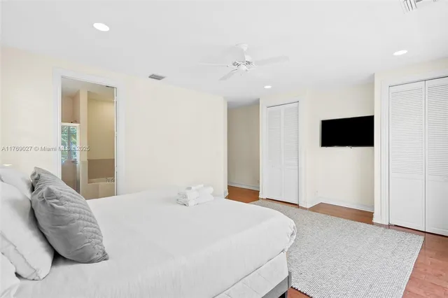 a bedroom with a large bed and a flat screen tv