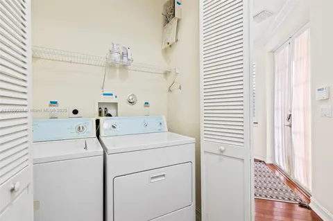 a view of washer and dryer with bathroom in the background