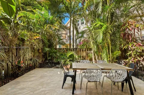 a view of patio with table and chairs and potted plants