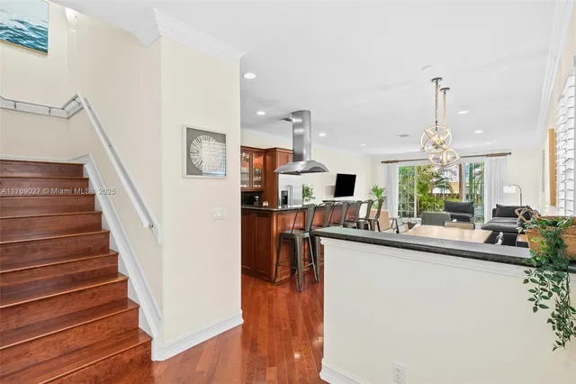 a dining hall with stainless steel appliances granite countertop a sink and dishwasher a stove with wooden floor