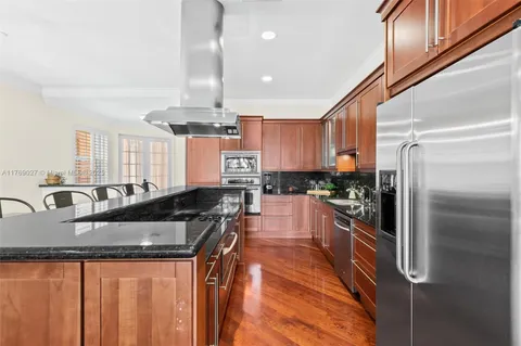 a kitchen with granite countertop a sink a counter top space appliances and cabinets