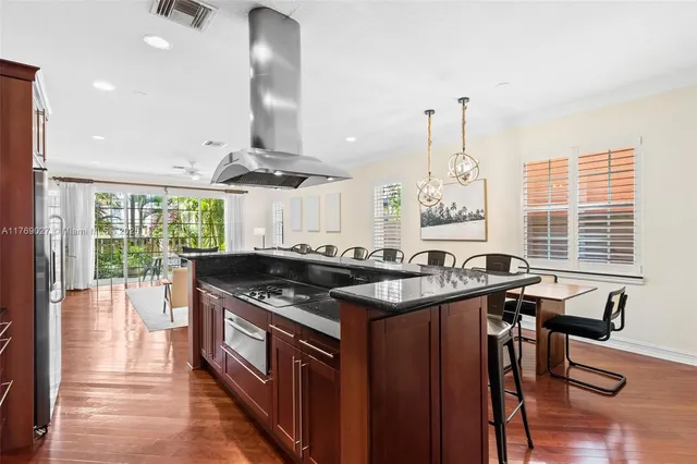 a kitchen with stainless steel appliances granite countertop a stove and a large window