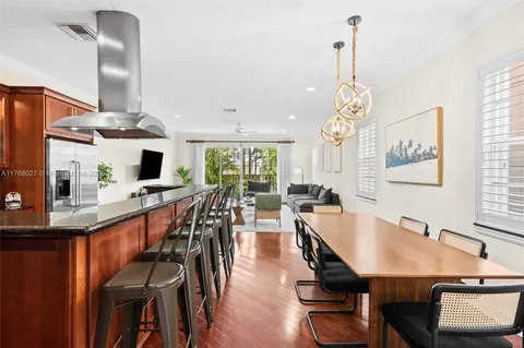 a dining room filled chandelier and wooden floor
