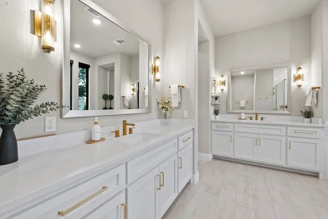 a spacious en suite bathroom with double sink and a mirror