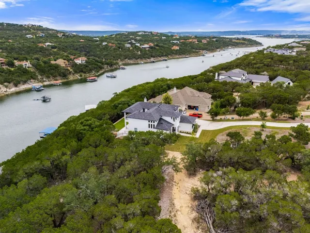 an aerial view of ocean and residential houses with outdoor space
